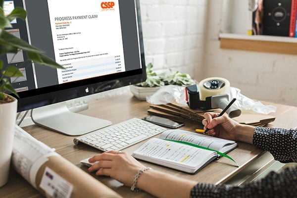 A woman utilising accounting software on a computer at a desk.