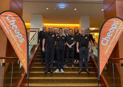 A group of people standing on stairs with orange banners, promoting ERP software in Australia.
